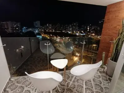 a balcony with white chairs and a view of a city at Barranco-Miraflores, ubicación A1, hermosa vista in Lima