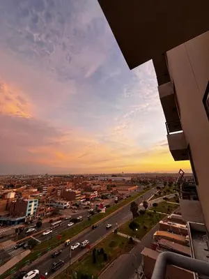 a view of a city at sunset with cars on a highway at Romi Apartment in Lima