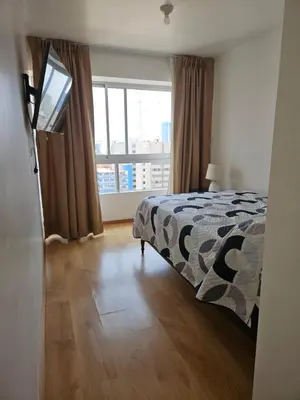 a bedroom with a bed and a large window at Flat Arenales in Lima