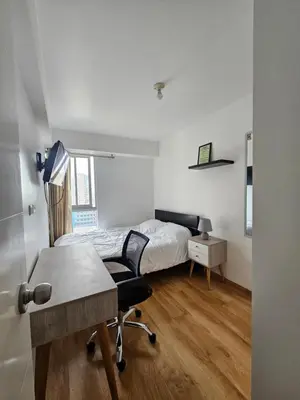 a bedroom with a bed and a desk and a desk at Flat Arenales in Lima