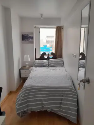 a bedroom with a bed and a large window at Flat Arenales in Lima