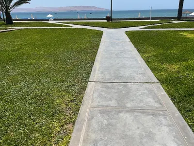 a walkway in a park next to the beach at Suite 1ra Fila Vista Bahía Paracas - Sotavento 601 T3 in Paracas
