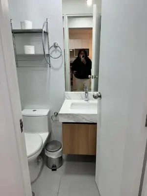 a woman taking a picture of a bathroom with a toilet and sink at San Isidro, lindo depa , 2tv wifi, piscina, lavanderia in Lima