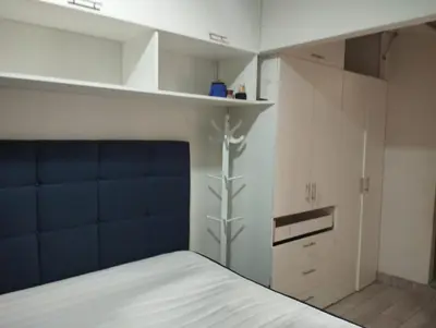 a bedroom with a bed with a blue head board at Departamento Duplex Aeropuerto y plaza cerca de ti! in Lima