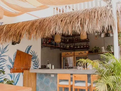 a bar in a restaurant with a straw roof at Narea San Bartolo in San Bartolo
