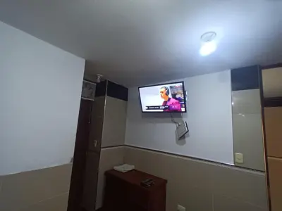 a bathroom with a tv on the wall in a room at HOSPEDAJE JOVITa in Lima