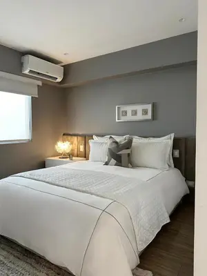 a bedroom with a large white bed and a window at Departamento de lujo Miraflores con Aire Acondicionado in Lima