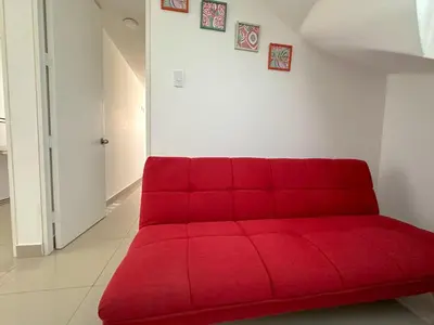 a red couch sitting in a living room at Apartamento exclusivo con terraza privada in Lima