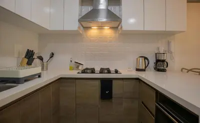 a kitchen with white cabinets and a stove top oven at Artline in Barranco by Wynwood House in Lima