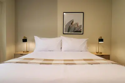 a bedroom with a white bed with two lamps at Treehouse by Wynwood house in Lima