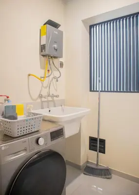a bathroom with a sink and a washing machine at Treehouse by Wynwood house in Lima