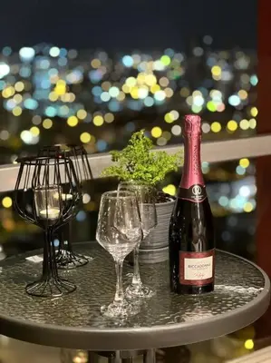 a table with two glasses and a bottle of wine at Premium Loft-Moderno y Acogedor in Lima