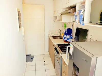 a small kitchen with a stove and a sink at Departamento Lima acogedor, ventilado, cálido y moderno San miguel, Lima, Perú in Lima