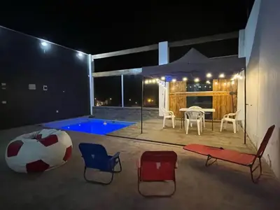 a patio with a soccer ball and chairs at night at Ali Home in Punta Negra