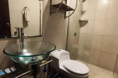 a bathroom with a glass sink and a toilet at Casa de 4 pisos cerca a embajada de USA y centros comerciales in Lima