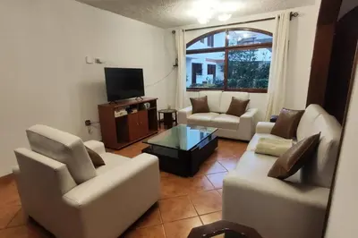 a living room with two couches and a tv at Casa de 4 pisos cerca a embajada de USA y centros comerciales in Lima