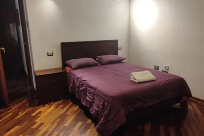 a bedroom with a large bed with purple sheets at Casa de 4 pisos cerca a embajada de USA y centros comerciales in Lima