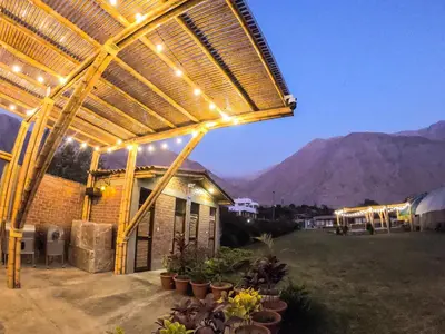 a building with a pergola with lights on it at Taypu bungalow in Lunahuaná