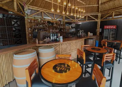 a restaurant with two tables and chairs and a bar at Taypu bungalow in Lunahuaná