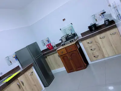 a kitchen with a black refrigerator and wooden cabinets at P2 Habitación Privada doble Miraflores, LIMA in Lima