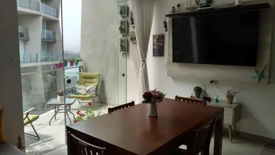 a dining room with a table and a television on a wall at Departamento en PLAYA San Bartolo in San Bartolo
