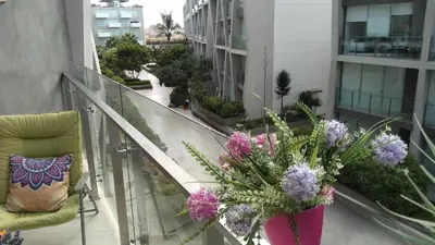 a balcony with a chair and flowers on a building at Departamento en PLAYA San Bartolo in San Bartolo