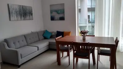 a living room with a couch and a dining room table at Departamento en PLAYA San Bartolo in San Bartolo