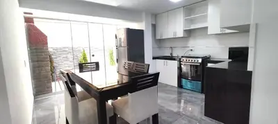 a kitchen with a dining table and a refrigerator at El Polo Surco in Lima
