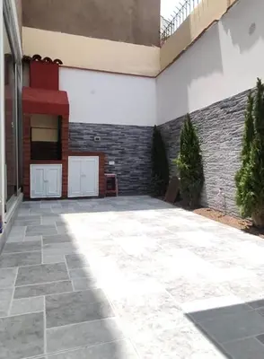 a patio with a brick wall and a building at El Polo Surco in Lima