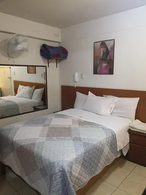 a hotel room with two beds and a mirror at Hs Baltimore in Lima