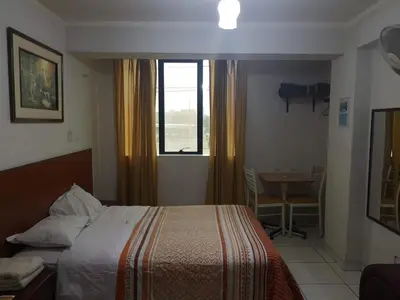 a bedroom with a bed and a window and a table at Hs Baltimore in Lima