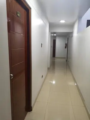a hallway with a wooden door and a hallwayngth at Hs Baltimore in Lima