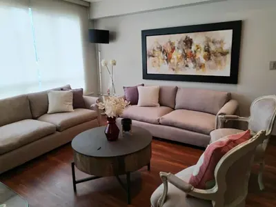 a living room with a couch and a table and chairs at El Libertador Apartment Miraflores in Lima