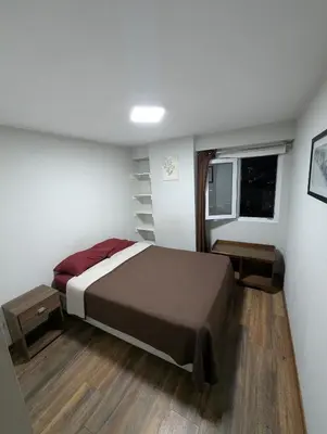 a bedroom with a large bed and a window at Guernica Apartments in Lima