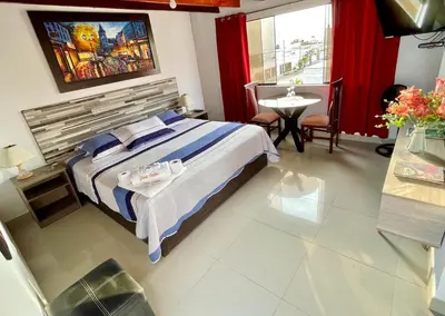 a hotel room with a bed and a table and a table at Hostal Ocean Pacifico in Punta Negra