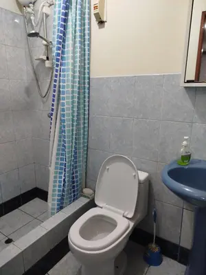 a bathroom with a toilet and a blue shower curtain at Habitación H2, TV y WIFI cerca a Barranco in Lima