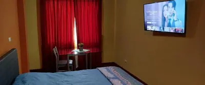a bedroom with a bed and a desk and a television at Habitación H2, TV y WIFI cerca a Barranco in Lima