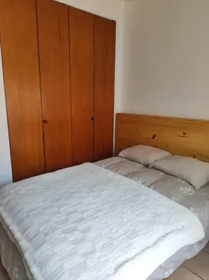 a bed in a bedroom with a wooden headboard at Cómoda habitación independiente Miraflores in Lima