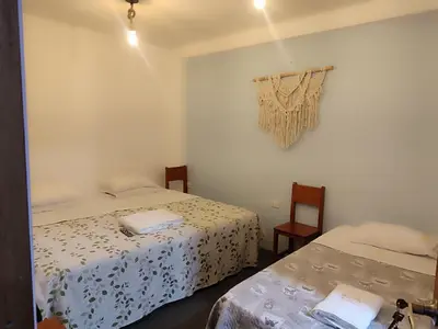 a bedroom with two beds and a window with a curtain at Hospedaje Velilu in Ica