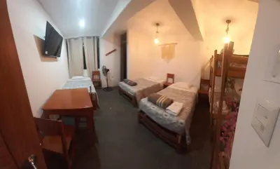 a small room with two beds and a table at Hospedaje Velilu in Ica