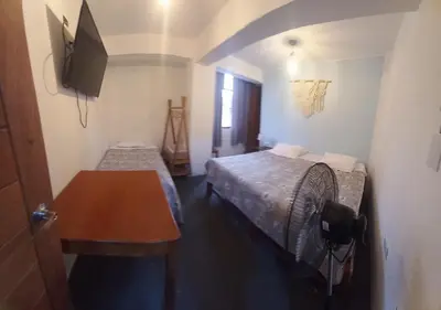 a small room with a bed and a fan at Hospedaje Velilu in Ica