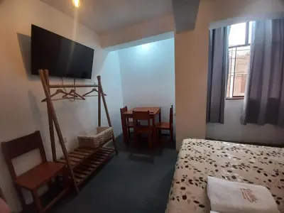 a bedroom with a bed and a tv and a table at Hospedaje Velilu in Ica