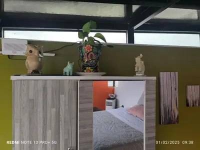 a room with a bed and a vase on a shelf at home Blessed III in Lima