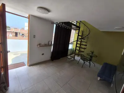 a living room with a staircase and a table and chairs at home Blessed III in Lima