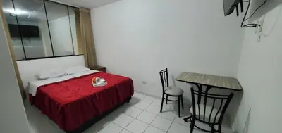 a bedroom with a bed and a table and a table at Hospedaje El Paraiso in Santa Eulalia