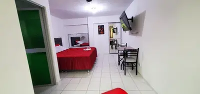 a room with a red bed and a table and chairs at Hospedaje El Paraiso in Santa Eulalia