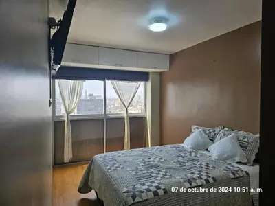 a bedroom with a bed and a large window at Departamento Pueblo Libre in Lima