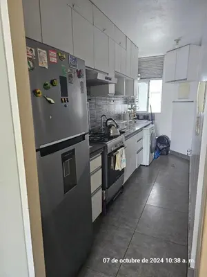 a kitchen with a stainless steel refrigerator and white cabinets at Departamento Pueblo Libre in Lima