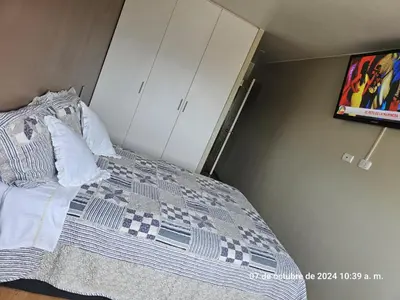 a bedroom with a bed and a tv on the wall at Departamento Pueblo Libre in Lima