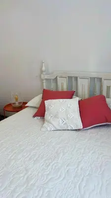 a bed with red and white pillows on it at Loft Huacachina center ica in Ica